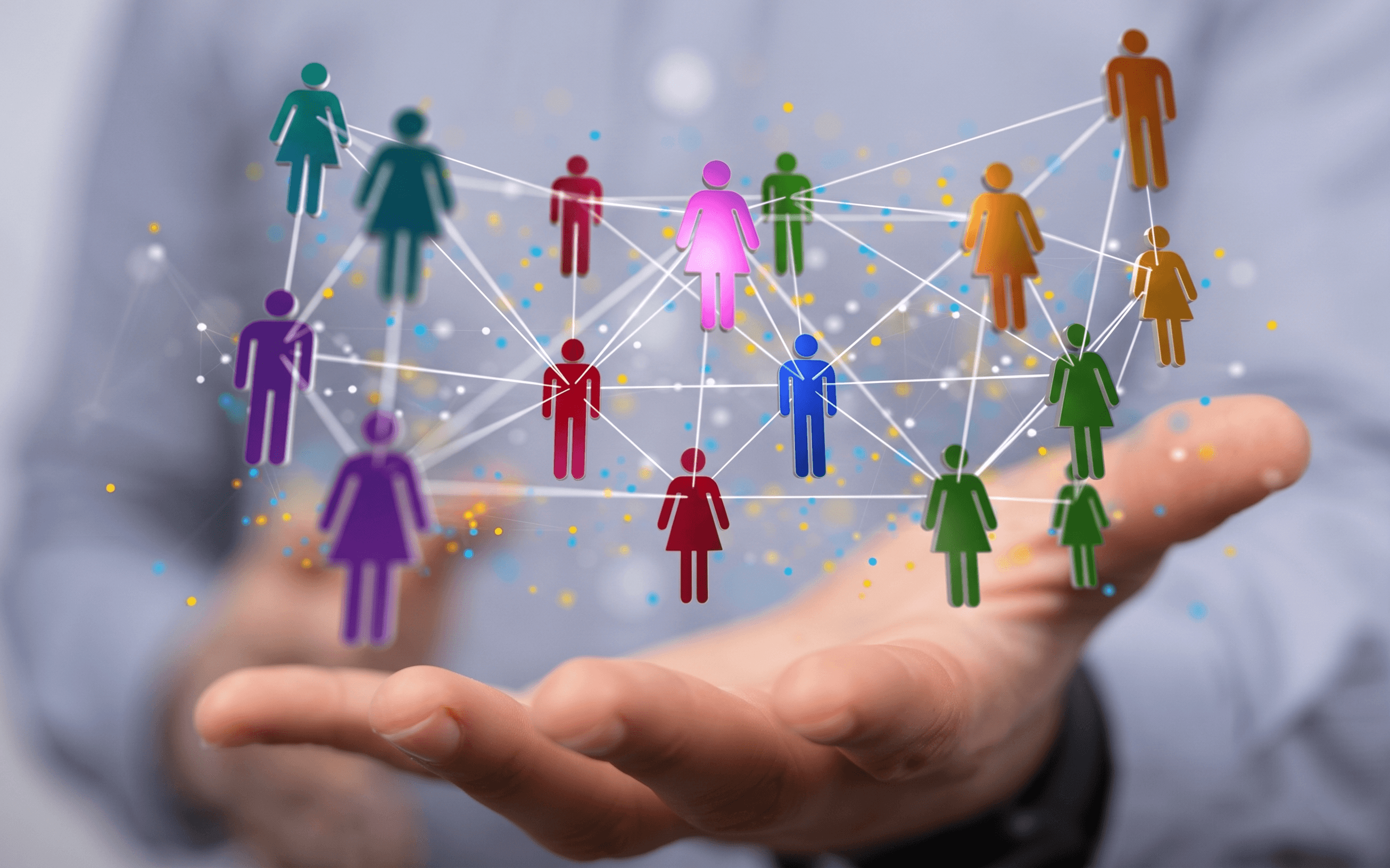 A diverse network of colorful people figures connected together, held in an open hand — illustrating the Networker community on Kootami.